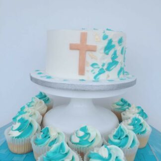 Buttercream vanilla cake decorated in blue and white theme with gold cross. 24 matching cupcakes from Blessing's bakery, Halden